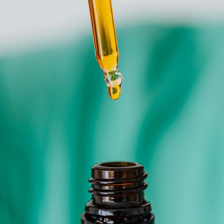 Detailed view of an amber glass bottle and dropper used in laboratory or medical setting, illustrating chemical experimentation.